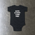Cute Is What I Aim For onesie in black, laid flat