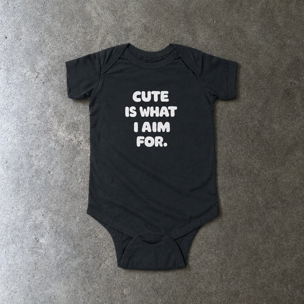 Cute Is What I Aim For onesie in black, laid flat