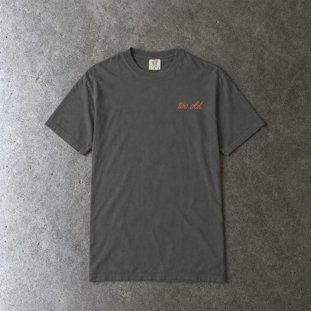 I'm Too Old For This Pit Danny Tee on Comfort Colors in pepper, laid flat