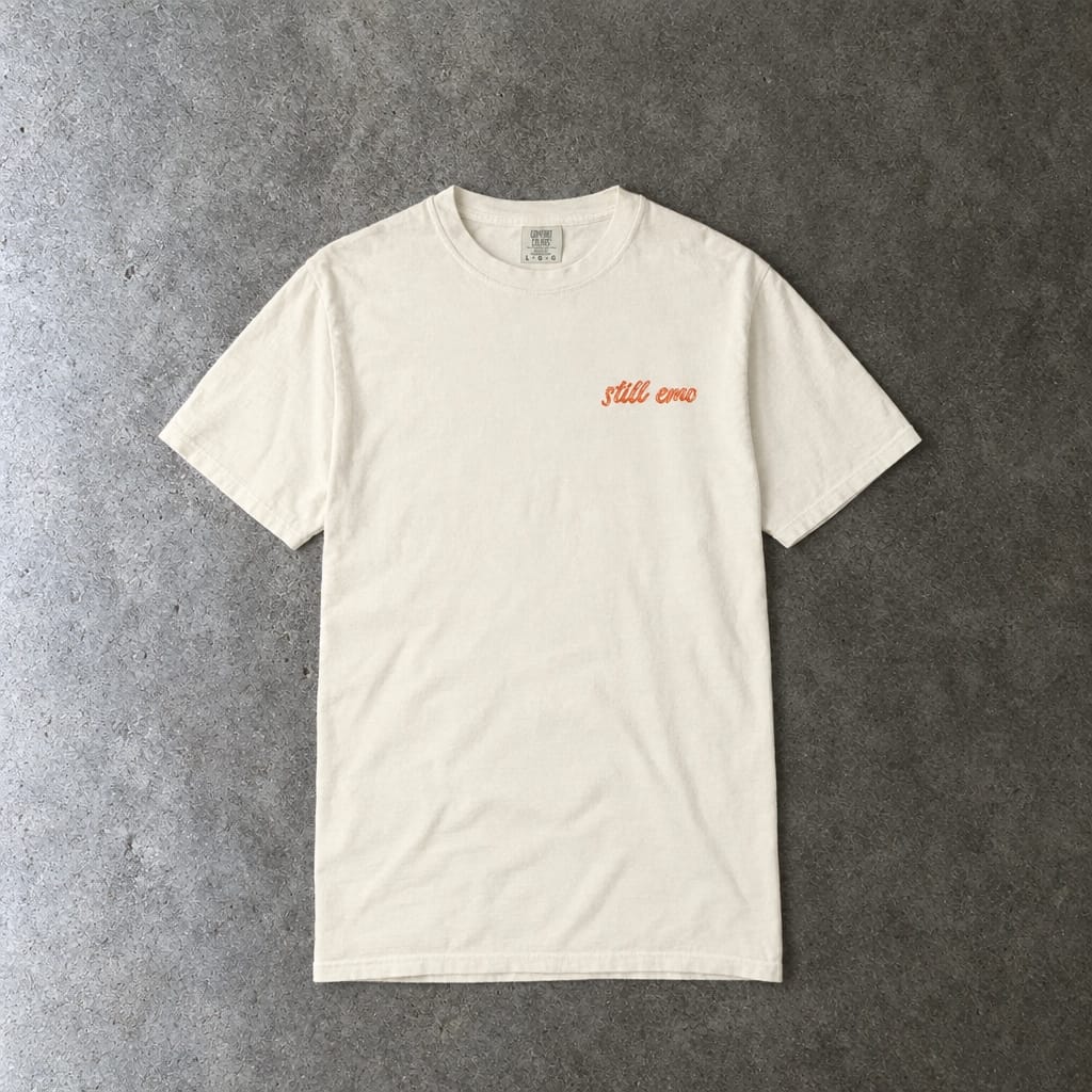 Still Emo Embroidered Tee in ivory, laid flat